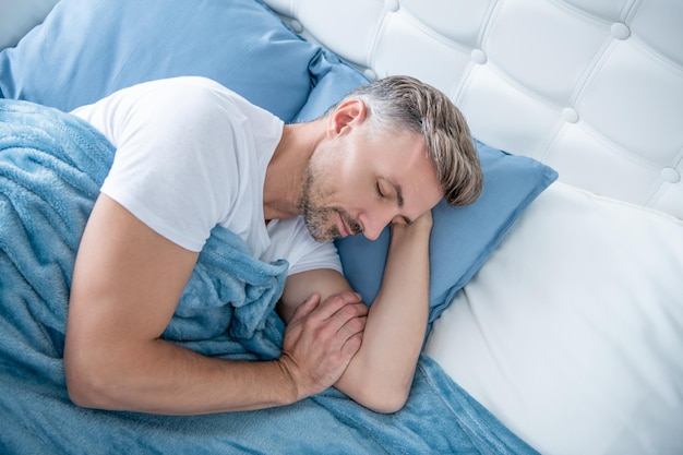 Homme mûr faisant la sieste au lit tôt le matin