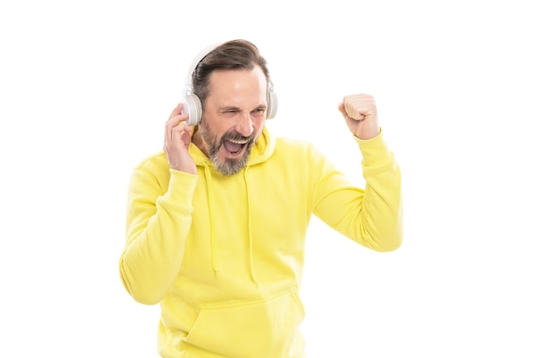 Homme mûr gai avec barbe et moustache en sweat à capuche, écoutez de la musique ou un livre audio dans des écouteurs isolés sur blanc, musique.