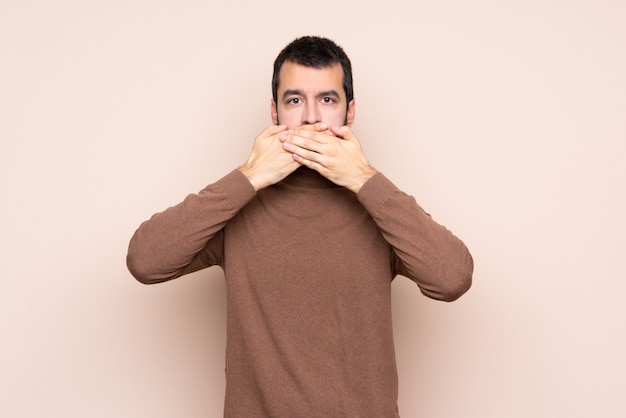 Homme sur mur isolé couvrant la bouche avec les mains