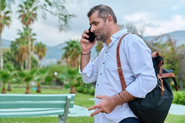 Homme mûr, parler au téléphone à l'extérieur