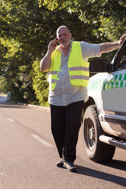 Un homme mûr passe un appel à côté de sa camionnette