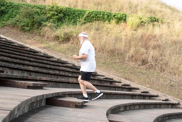 Homme mûr plus âgé en bonne forme lors d'un exercice de montée d'escaliersMode de vie sain pour la retraite