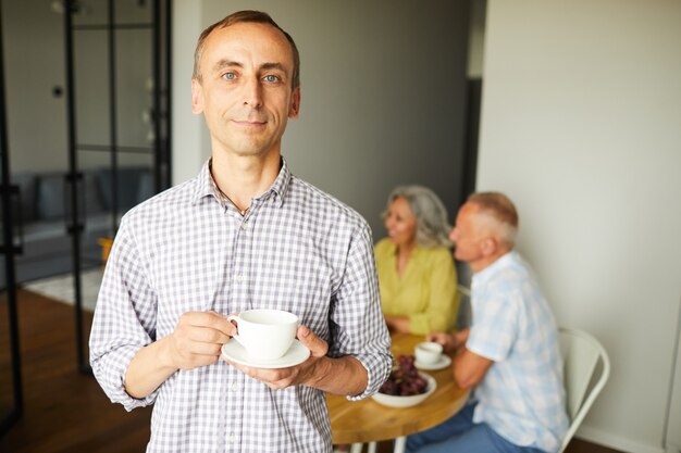 Homme mûr, poser, à, tasse thé