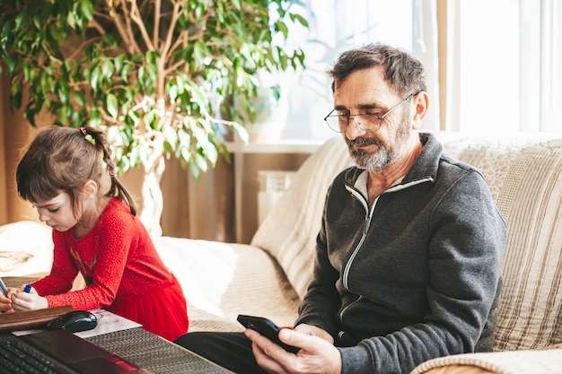 Homme mûr et sa petite-fille faisant leurs propres choses