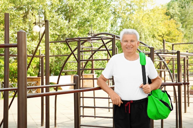 Homme mûr avec sac à l'extérieur