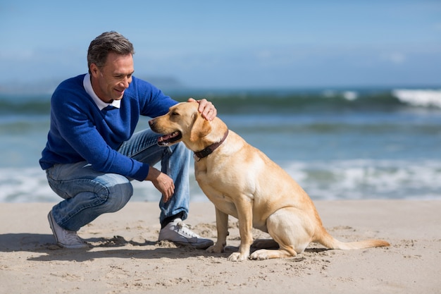 Homme mûr avec son chien sur la plage