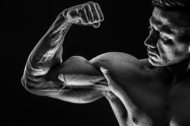 Homme musclé athlétique fort montrant les biceps