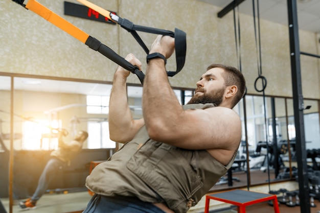 Homme musclé barbu vêtu d&#39;un gilet blindé militaire faisant des exercices