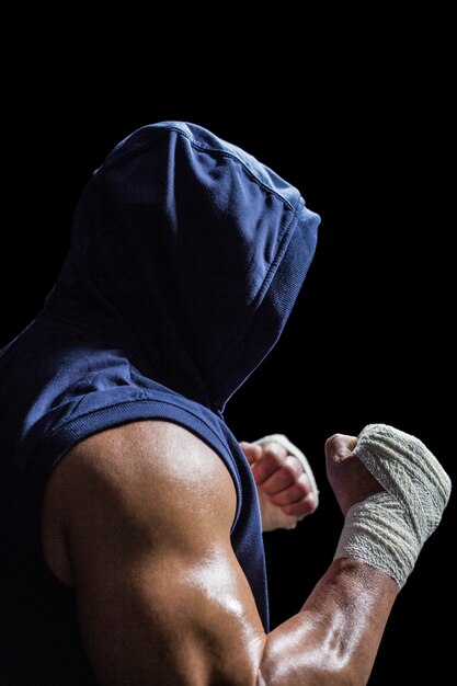 Homme musclé en capuche bleue avec position de combat