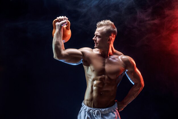 Homme musclé concentré, faire de l'exercice avec kettlebell