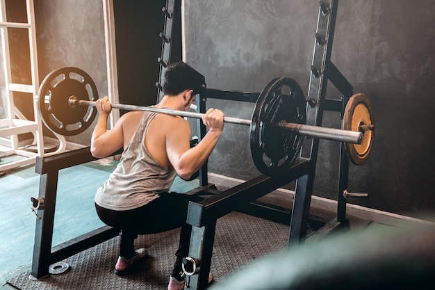 Homme musclé construit athlète travaillant dans la salle de gym