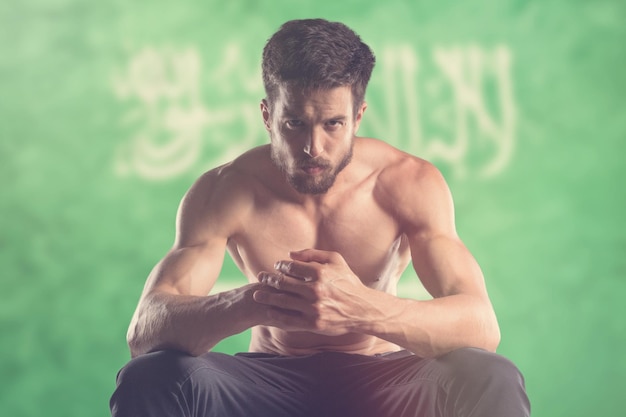 Homme musclé avec le drapeau de l'Arabie saoudite derrière