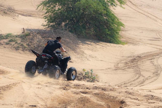 Homme musclé équitation VTT dans le désert.