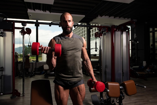 Homme musclé exerçant des biceps avec haltère