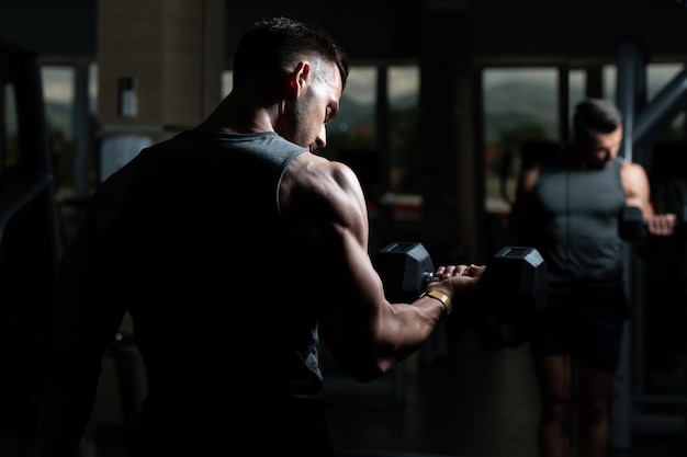 Homme musclé exerçant des biceps avec haltère