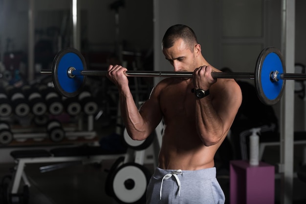 Homme musclé exerçant des biceps avec des haltères