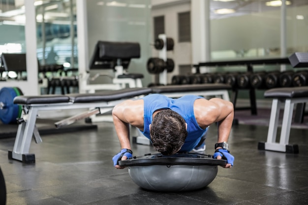 Homme musclé, faire, poussez, à, balle bosu, à, les, gymnase