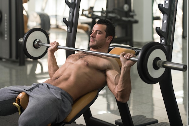 Photo un homme musclé faisant de l'exercice au gymnase.