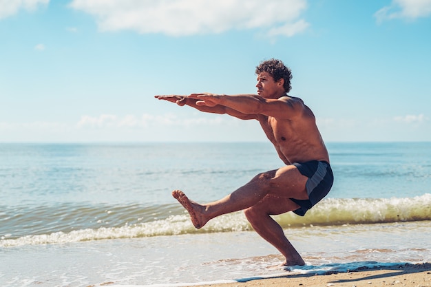 Homme musclé faisant de l'exercice sur l'entraînement du corps de plage