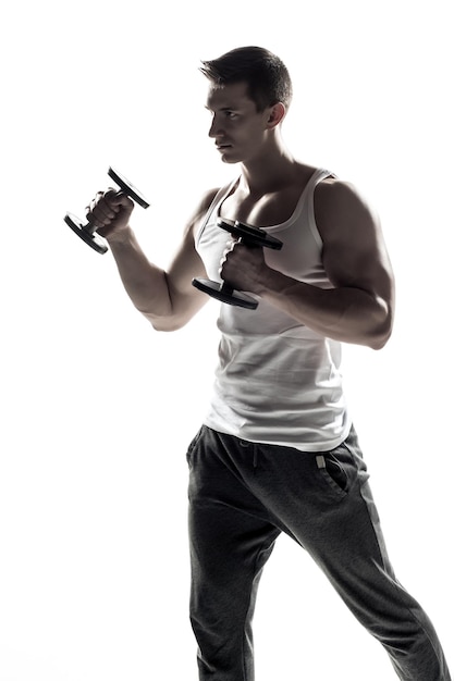Homme musclé faisant des exercices avec des haltères isolés sur fond blanc