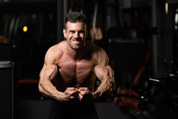 Homme musclé, flexion des muscles dans la salle de gym