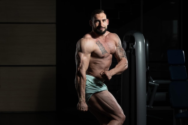 Homme musclé, flexion des muscles dans la salle de gym