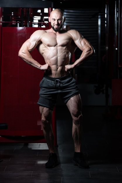 Homme musclé, flexion des muscles dans la salle de gym