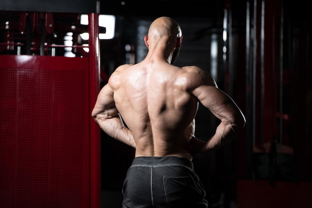 Homme musclé, flexion des muscles dans la salle de gym