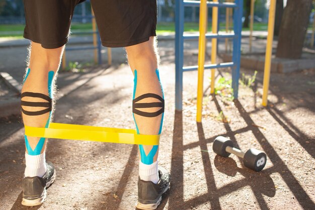 Homme Musclé Formation Bande De Résistance De Remise En Forme Sur Les Jambes Au Terrain De Sport