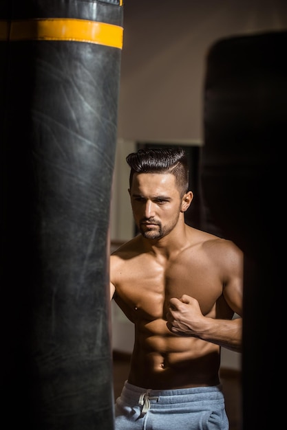 Homme musclé avec sac de boxe