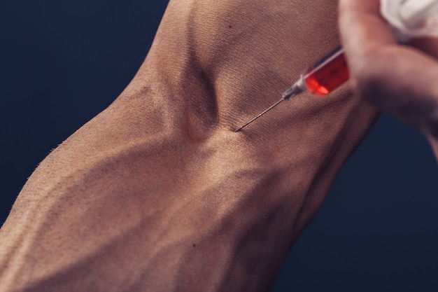 Un homme musclé avec une seringue