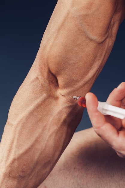 Un homme musclé avec une seringue