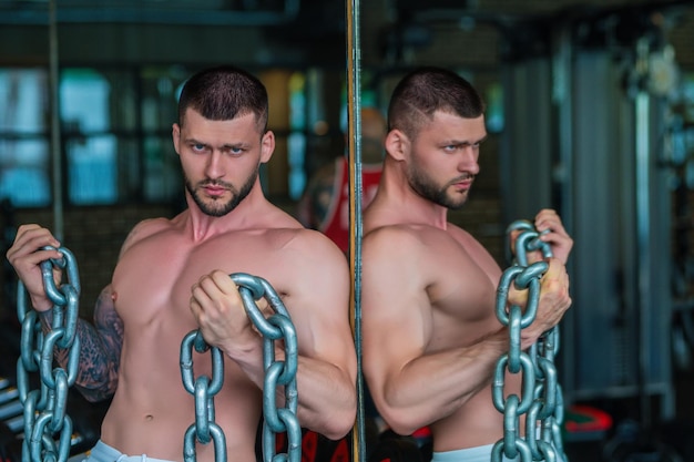 Photo homme musclé, soulever des poids au gymnase beau mec se prépare à faire des exercices avec haltère