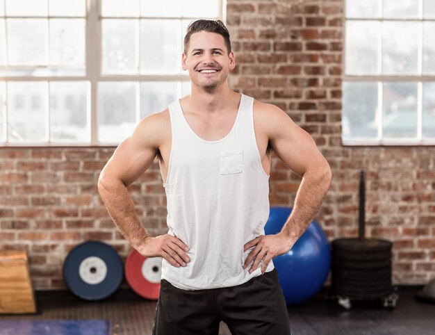 Homme musclé souriant avec les mains sur les hanches