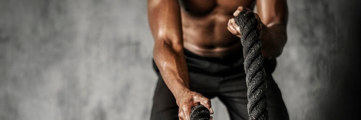 Photo homme musclé travaillant sur les cordes de combat dans une salle de sport