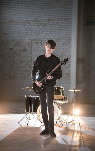 Un homme musicien jouant de la guitare basse dans le hangar