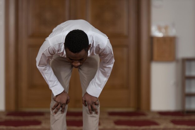 L'homme musulman africain noir prie dans la mosquée