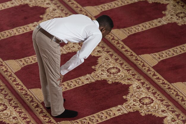 L'homme musulman africain noir prie dans la mosquée