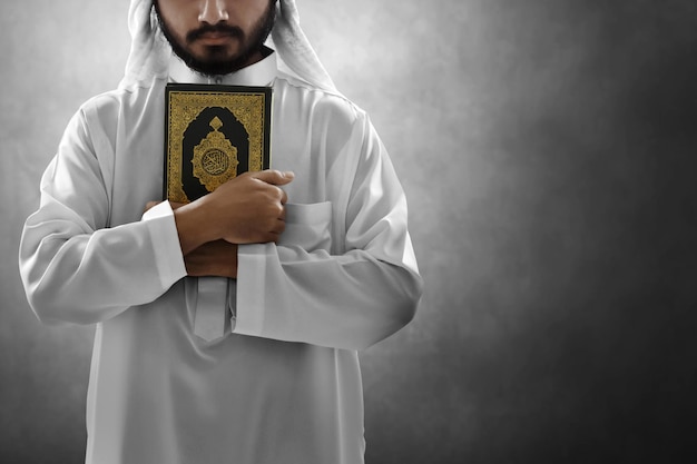 Un homme musulman arabe religieux tenant le Saint Coran