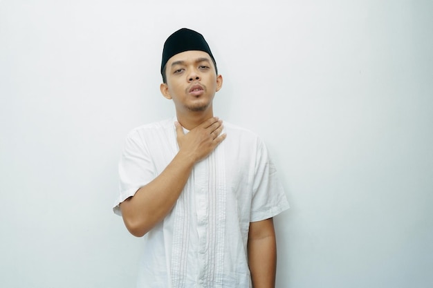 Photo un homme musulman asiatique indonésien assoiffé a mis sa main sur le cou et la gorge.