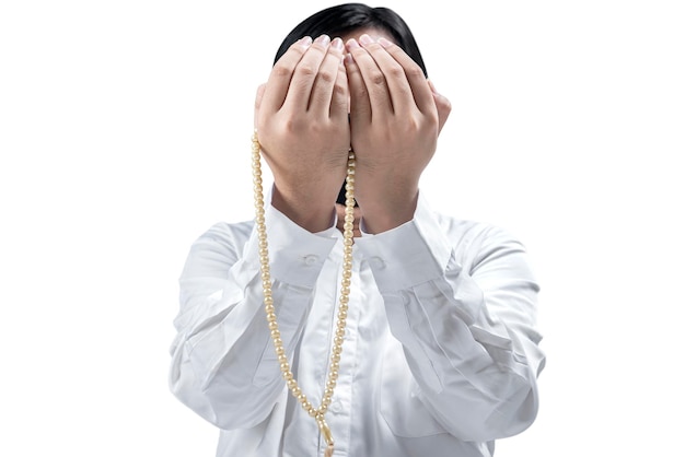 Homme musulman asiatique priant avec un chapelet sur ses mains isolé sur fond blanc