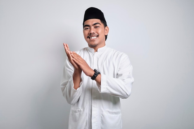 Homme musulman asiatique souriant applaudissant dans les mains et regardant la caméra