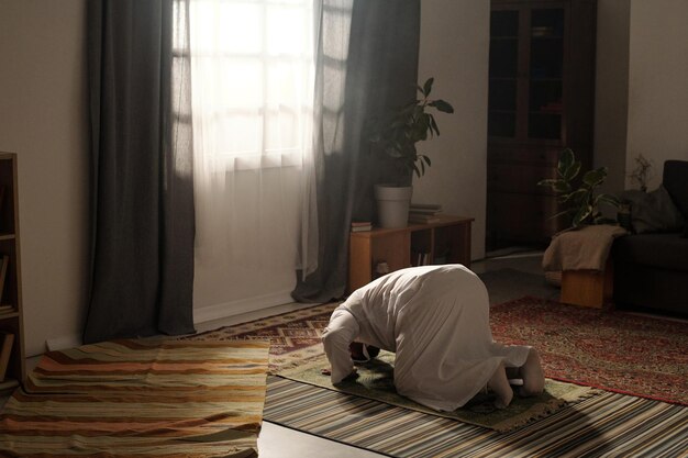 Photo un homme musulman fait la namaz à la maison.