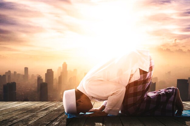 L'homme musulman fait Salat avec le fond de la ville