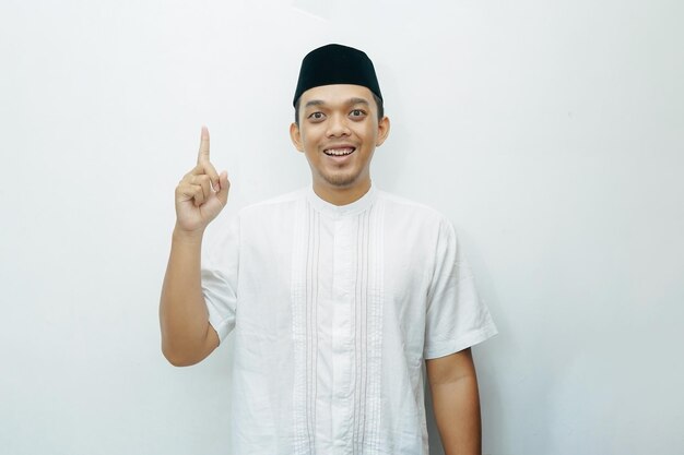 Photo un homme musulman indonésien asiatique souriant montre le doigt pointeur vers le haut