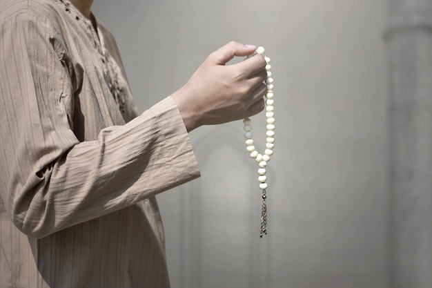 Homme musulman priant avec des perles de prière