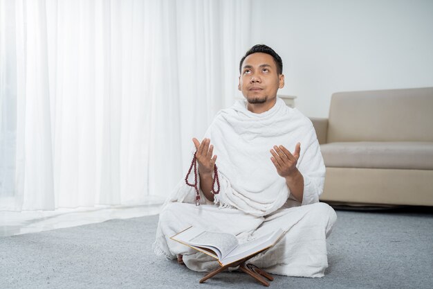 Homme musulman priant en vêtements traditionnels blancs