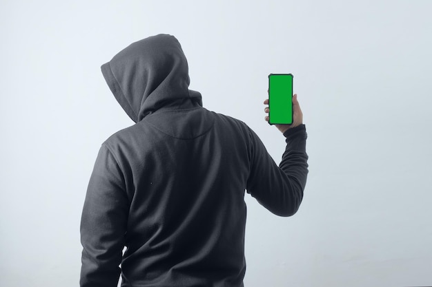 Homme mystérieux portant un sweat à capuche et tenant un téléphone