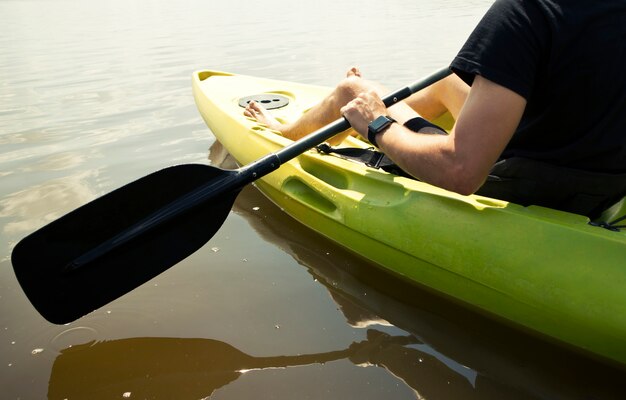 L'homme nage sur un kayak sur le lac