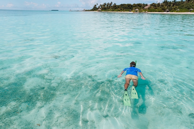 Homme nageant dans l'océan incroyablement turquoise